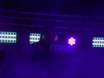 Cranes performing a dj set with heavy fog and purple light