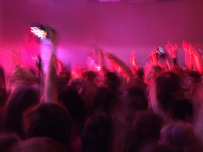 Blurry photo of crowd with raised hands