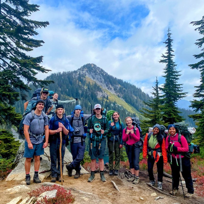 Group of hikers with mountain and trees in the background