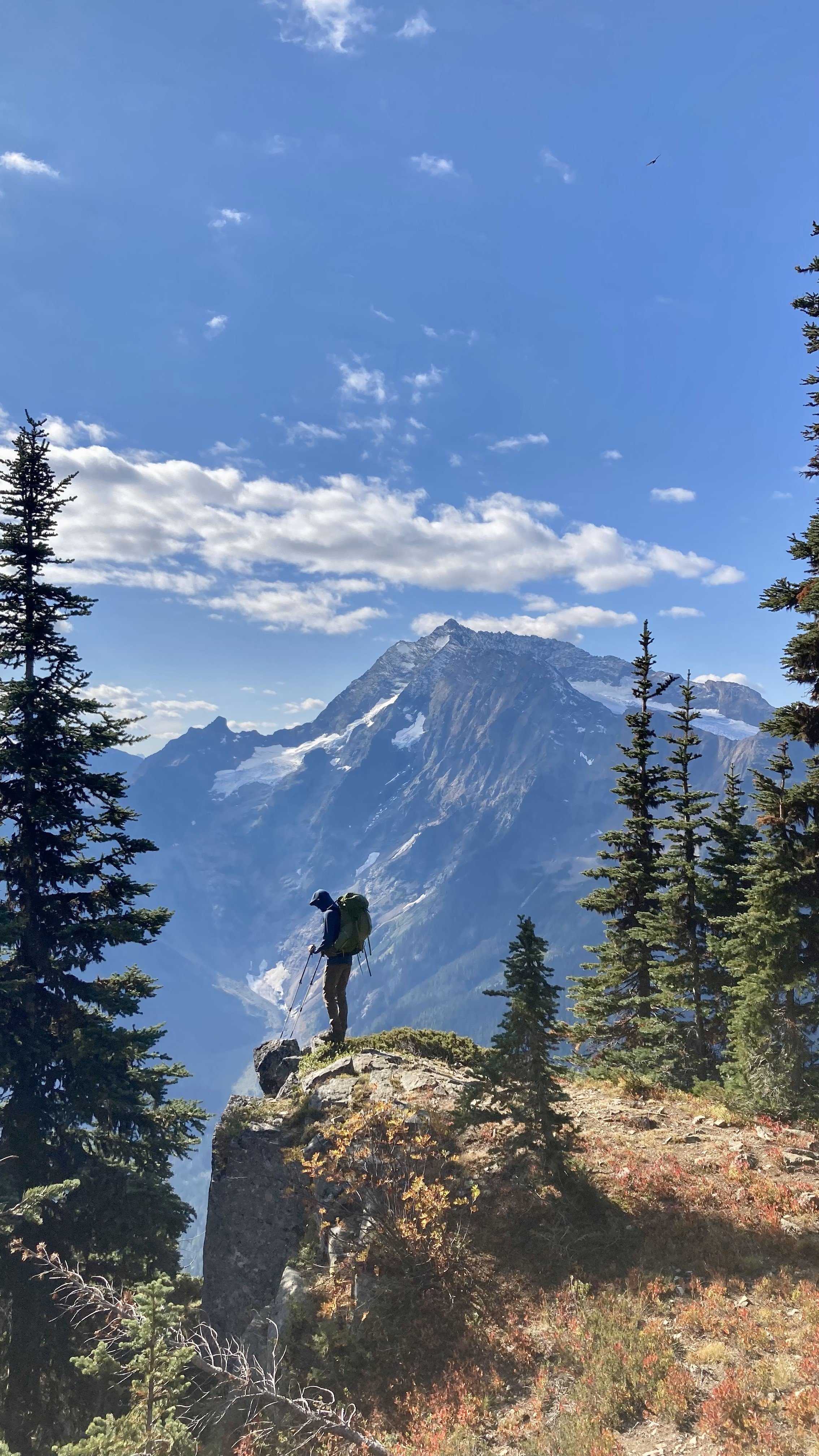 Standing over a cliffside with a mountain in the background