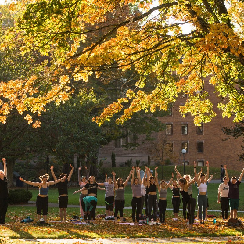 Students doing yoga on the lawn in front of Old Main