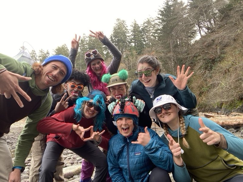 Students dressed up and smiling in front on a beach