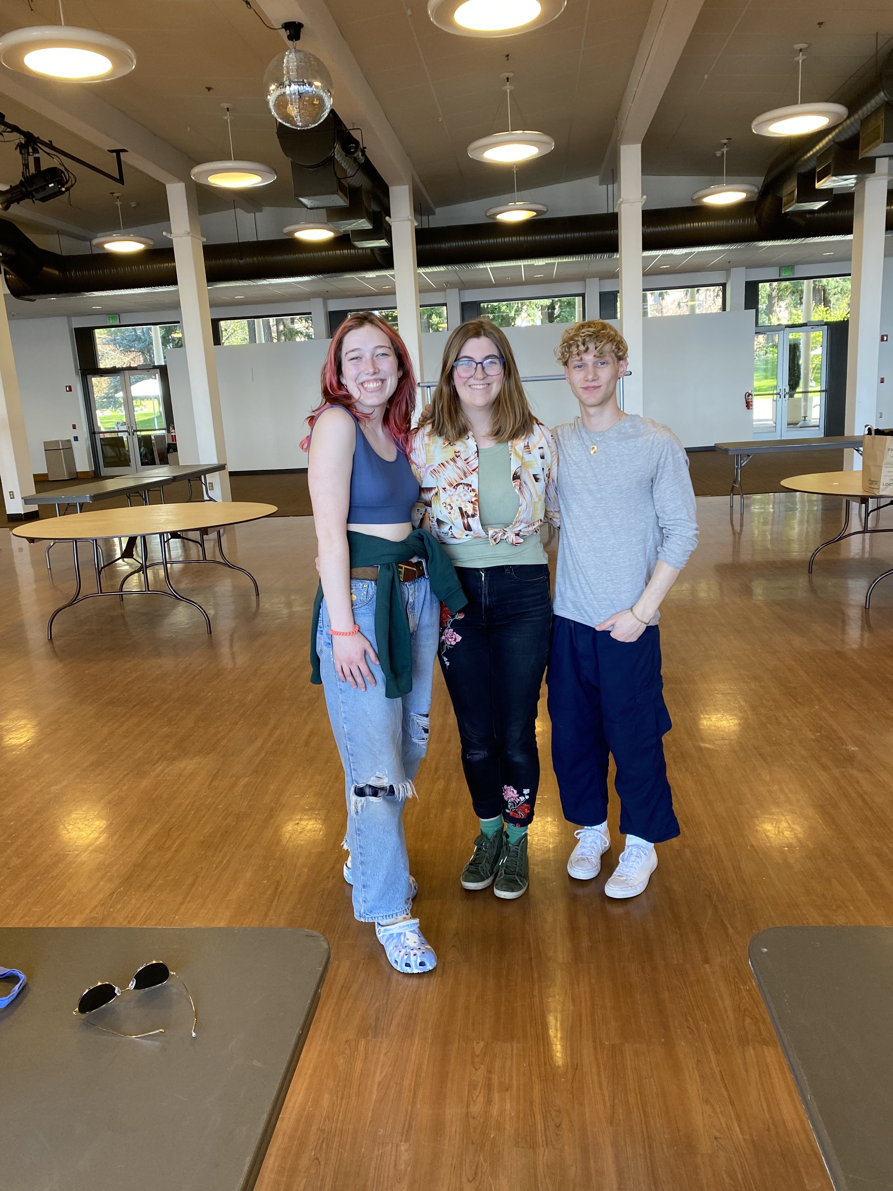 Emma, Kait (2021-2023 zero waste coordinator), and Ethan smiling after clothing swap and repair event.