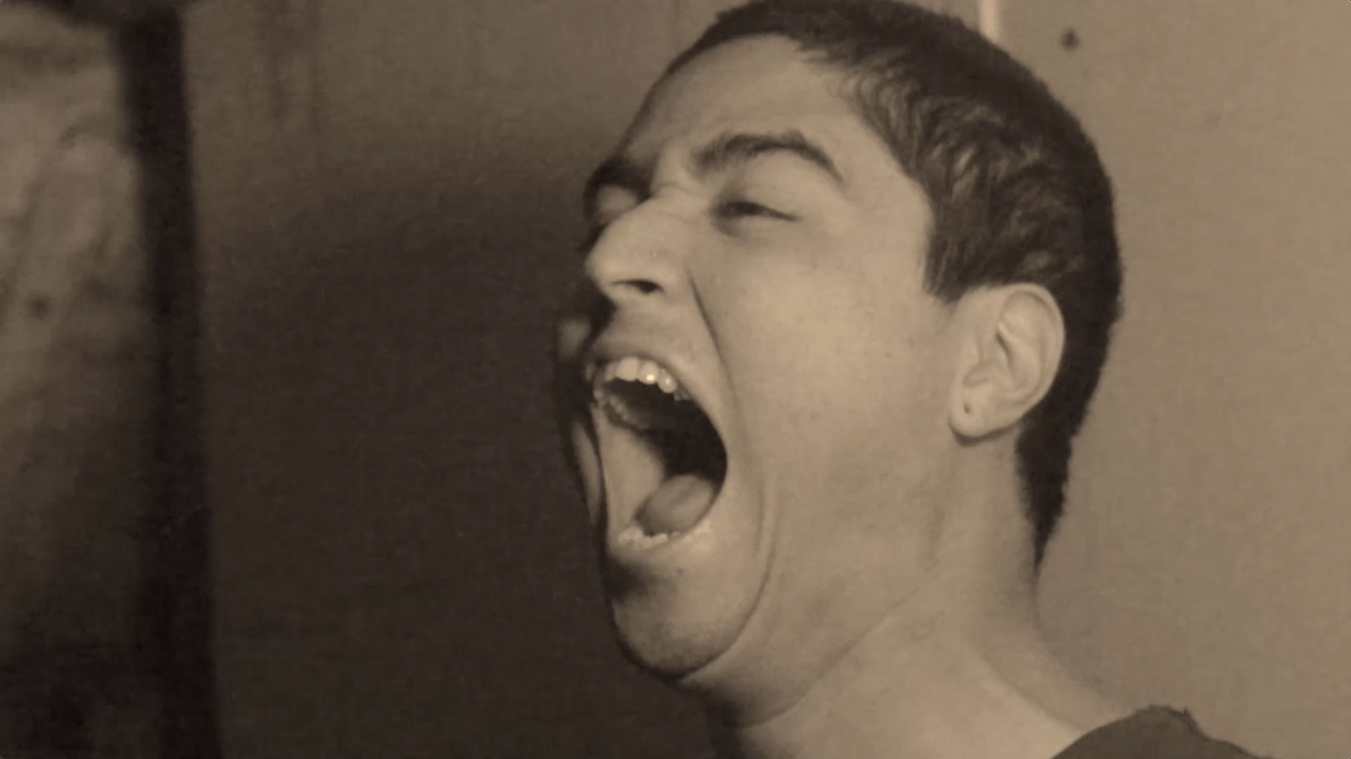 Screen capture of a digital short film which shows a sepia toned scene of the actor screaming