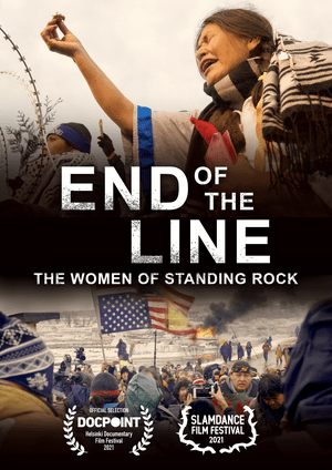 image shows the title of the film, End of the Line: The Women of Standing Rock, and above the title shows indigenous women making prayerful gestures in front of a barbed wire barrier. At the bottom of the image is a scene of protest with the American flag on fire. Icons show that the film won awards at both the Docpoint and Slamdance film festivals.