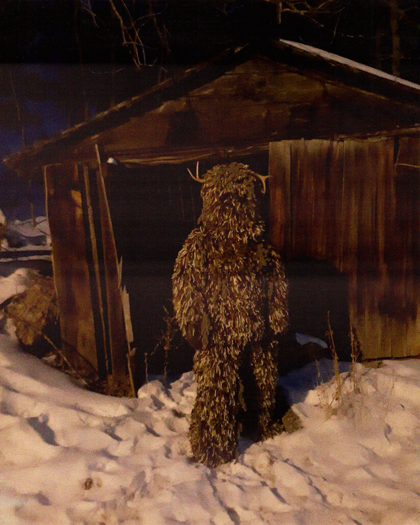 Alternate view of figure wearing artwork outdoors in front of a shed while standing in snow 2.png