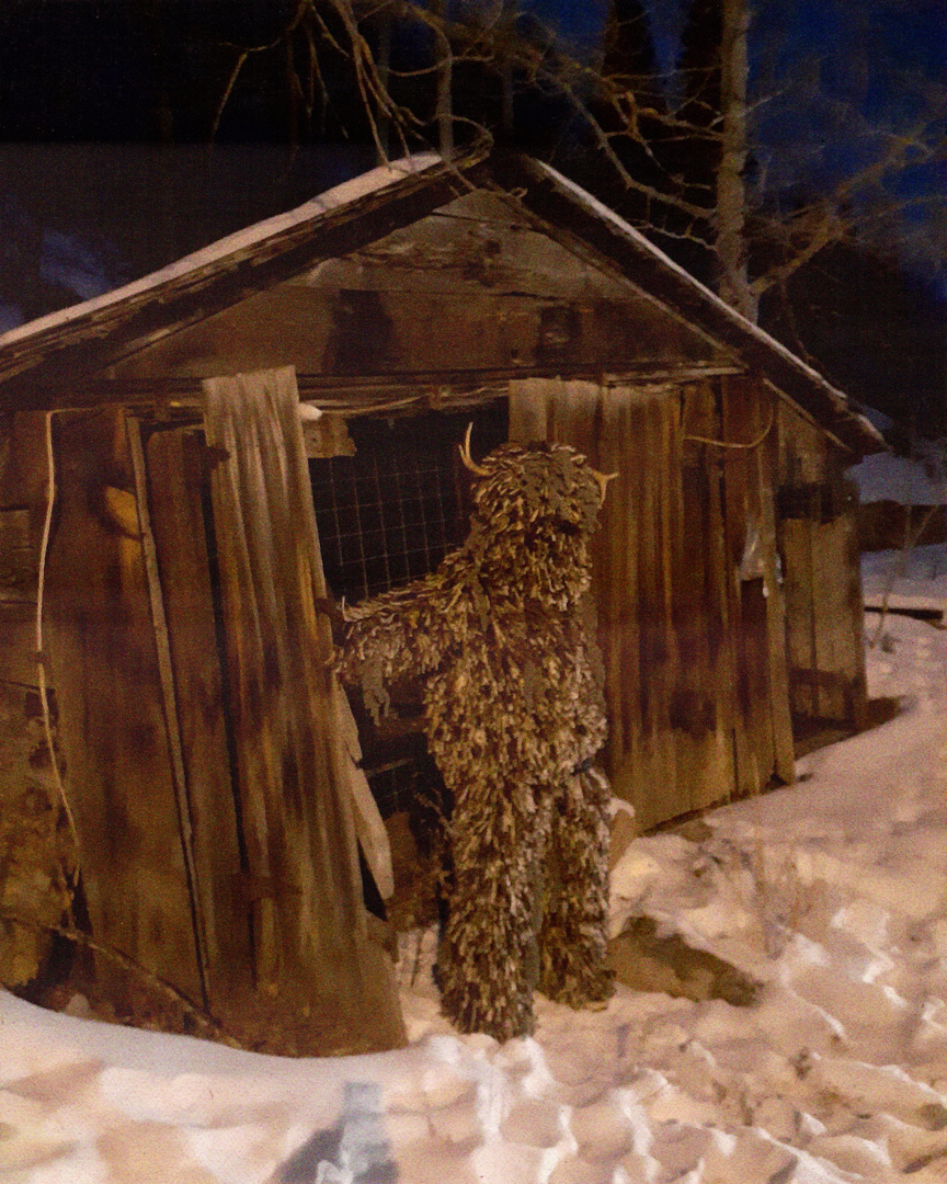 Alternate view of figure wearing artwork outdoors in front of a shed while standing in snow 3.png